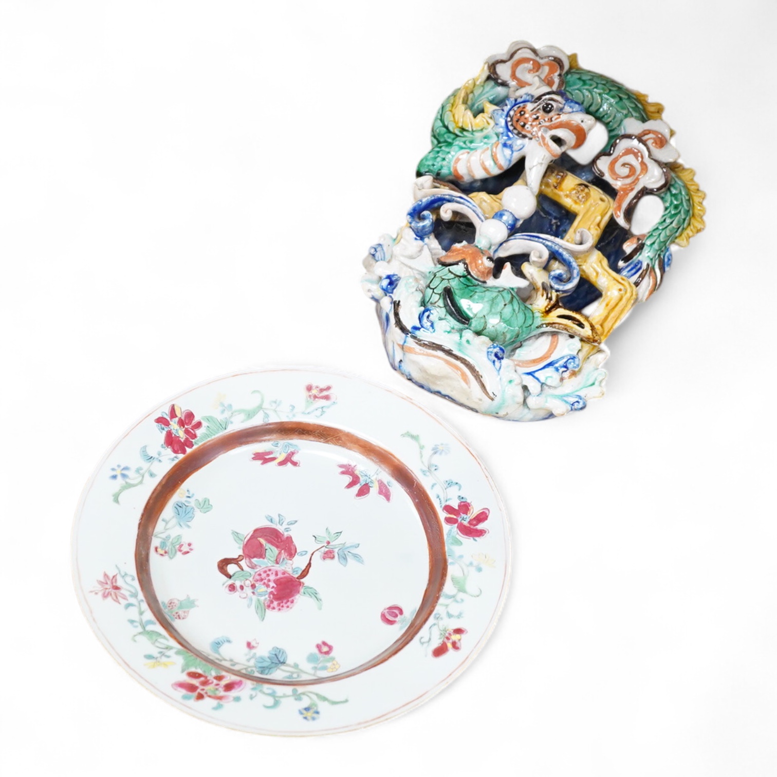 An 18th century Chinese porcelain plate enamelled with flowers and a Chinese Sancai type wall pocket, largest 25cm high
